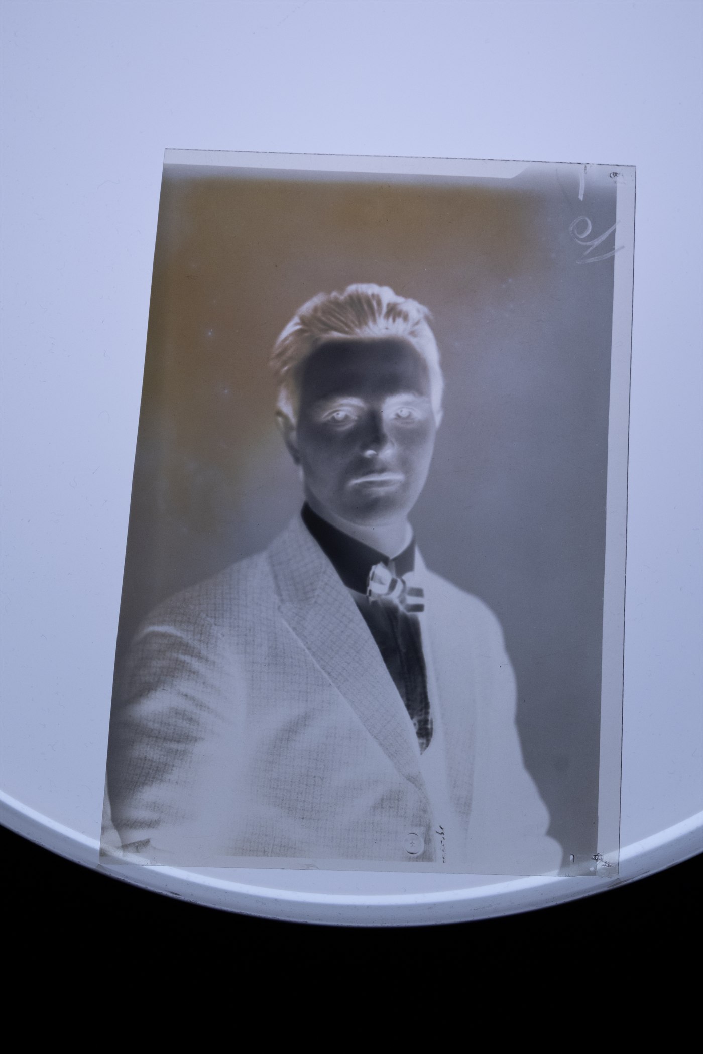 Originalt gammelt negativ fotografert mot lys før digital restaurering